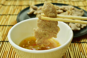 boiled  pork slice picking by wooden chopsticks dipping spicy sauce