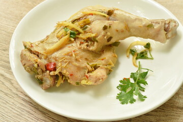 steamed spicy chicken thigh and leg with slice ginger on palte