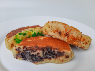 Pukis, is an Indonesian traditional pancake, with various toppings. On white plate. Isolated in white background.