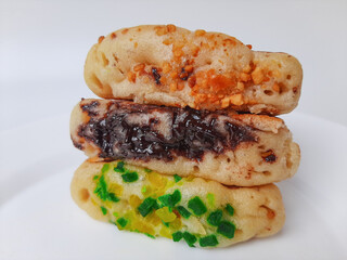 Pukis, is an Indonesian traditional pancake, with various toppings. On white plate. Isolated in white background.