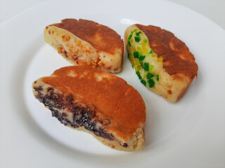 Pukis, is an Indonesian traditional pancake, with various toppings. On white plate. Isolated in white background.