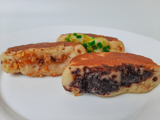 Pukis, is an Indonesian traditional pancake, with various toppings. On white plate. Isolated in white background.