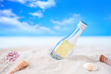 Fototapeta na wymiar bottle on sand beach with seashell over blurred tropical blue sea and clear blue sky