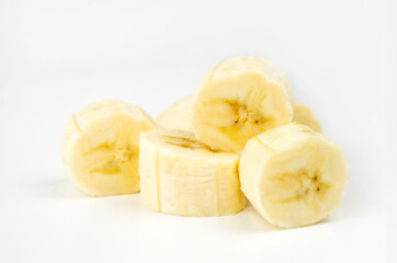 Banana slices on a white background. Peeled and chopped ripe banana. Yellow tropical fruit isolated on white