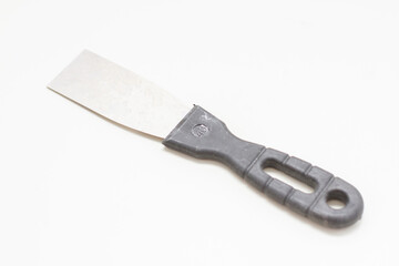 Putty knife with black handle on white background.