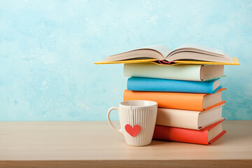 Fototapeta na wymiar Stack of books and mug on wooden table