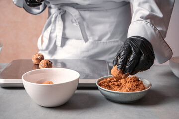 The chef prepares a date candy in the cocoa or carob