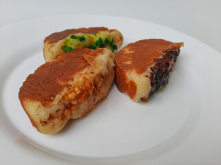 Pukis, is an Indonesian traditional pancake, with various toppings. On white plate. Isolated in white background.