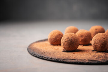 Round candy made of dates and carob on a slate Board near the copy space close-up