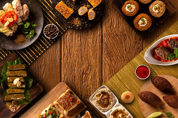 Middle eastern or arabic dishes and assorted meze on a wood background.  Baba ghanoush, hummus, sambusak, kibbeh, pita. Halal food. Space for text. Top view