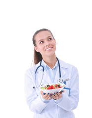 Portrait of a beautiful woman doctor holding a plate with fresh vegetables. Woman doctors.