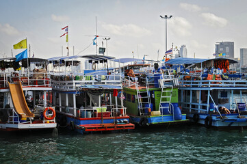 Fototapeta na wymiar Bateau de tourisme colorés accostés au port de Pattaya en Thaïlande.
