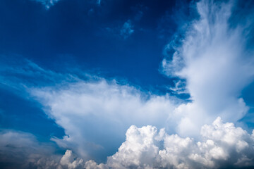 Blue and white cloudy sky after the thunderstorm including cirrus and cumulus clouds with sunlight.
