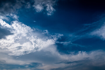 Blue and white cloudy sky after the thunderstorm including cirrus and cumulus clouds with sunlight.
