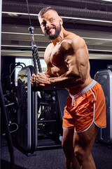 Handsome male bodybuilder in gym. Big strong man during training in the gym. Guy with big muscles...