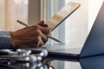Male doctor hand holding and using modern digital tablet, 
work on laptop computer with medical...