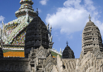 Vue sur des pagodes bouddhiste au palais impérial de Bangkok. Sculpture en pierre avec des détails très fins et mosaïque très fine sur fond de ciel bleu et jeu d'ombre et de lumière.