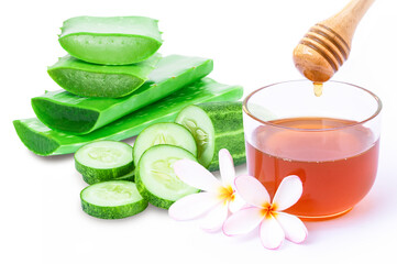 Obraz na płótnie Canvas Closeup green fresh cucumber and aloe vera slice with honey in glass bowl isolated on white background. Natural medicine plant, beauty and spa concept. 