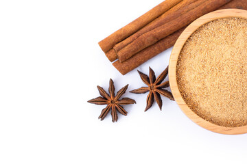 Cinnamon powder in wooden bowl and cinamon sticks with star anise isolated on white background. Natural herbal plant,spices seasoning concept. Top view.