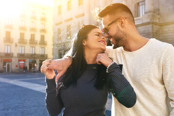 Young handsome guy and his lovely girlfriend are spending vacation in Barcelona. They look really happy and in love. The couple is strolling along the streets of the old town, seeing attractions