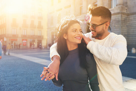 Happy Young Couple Is Spending Vacation Holidays In Barcelona City. Both Look Really Happy. They Are Strolling Along The Streets Of The Old Town And Hanging Out With Pleasure, Seeing Attractions.