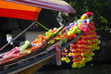 Gros Plan sur la proue fleurie d'un long-tail boat sur le fleuve chao Praya à Bangkok. Les décorations multicolores et guirlandes de fleurs sont des porte-bonheur pour les navigateurs thaïlandais. 