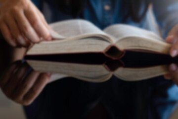 Blurred image woman reading a book.