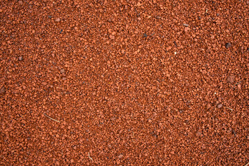 Background of brown sandy ground full of pebbles.
