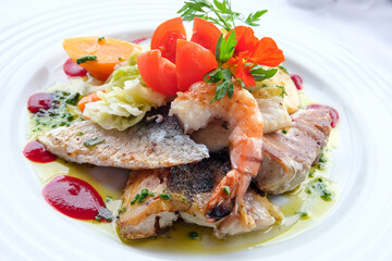 Delicious fish dish from traditional cuisine of Madeira island - grilled fillets of ocean codfish served with shrimps, shells, mussels and celery puree