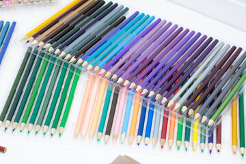 Colored pencils on a white background, close-up photo.
