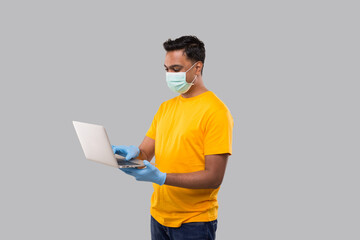 Indian Man Using Laptop Green Screen Wearing Medical mask and Gloves. Home orders, Quarantine delivery, Shopping Online, Freelance Worker Concept.