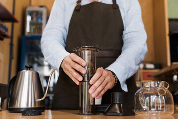 Aeropress coffee alternative making by barista in the cafe. Barista connect details from aeropress together. prepare aeropress to pour it. Advert for cafe, restaurants.