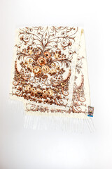 top view on flat beige cotton scarf with fringe and bright floral ornament