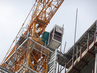 Fototapeta na wymiar KUALA LUMPUR, MALAYSIA -MAY 15, 2020: Tower Crane used to lift the heavy load at the construction site. Manually operate by the operator. Normally used at huge scale or high rise building construction