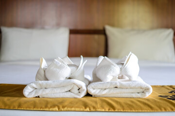 Fototapeta na wymiar white pillows and towels on a bed in hotel. bedroom service for resort.