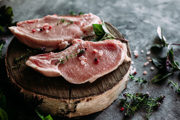 Raw pork steak on a bone on a table with pepper and salt