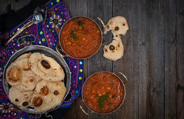 Indian chickpea garbanzo chole masala curry with naan in traditional bowls, copy space