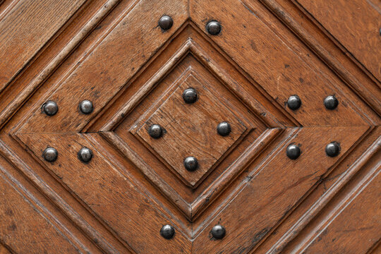 Texture of a wooden door with metal rivets. Wood diamond pattern