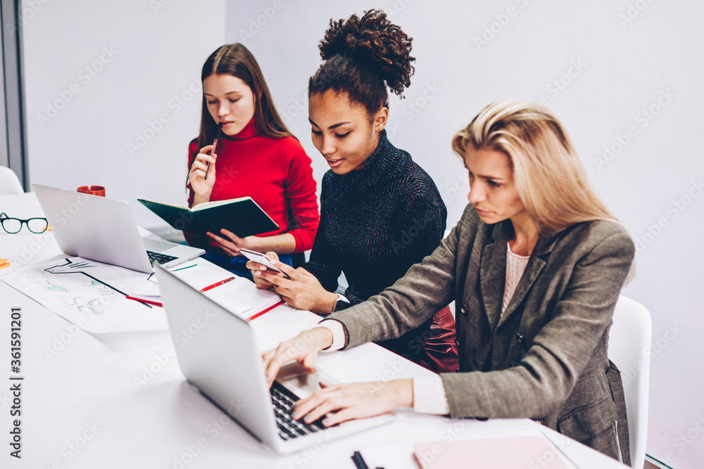 Aufkleber female students learning and doing homework in college classroom with wifi connection ignoring real 