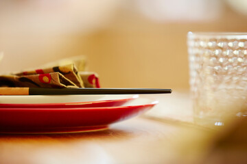 Plates with napkin and chopsticks on dining table