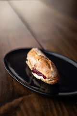 French baguette with hot Camembert cheese with jam in black plate