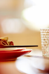 Plates with napkin and chopsticks on dining table
