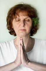 A portrait of a woman with closed eyes praying