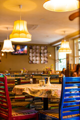 The cozy interior of the cafe. Warm yellow light chandeliers and checkered sofas