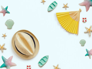 Creative travel background. Layout of various sea figures (starfish, boats, anchor, lifebuoy, shells), a straw hat and a paper fan. Preparing for vacation and travel.