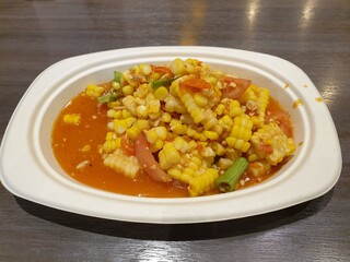 Corn Spicy Salad on a paper plate, placed on a wooden table