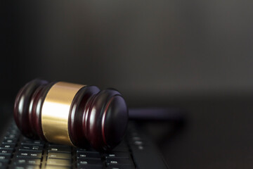 Judge's gavel on computer keyboard on black background with copy space. Cyber crime, law and...
