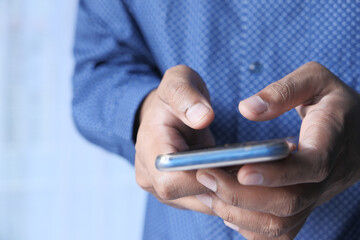 Businessman hand holding smart phone texting message 