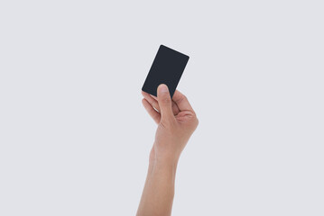 Close up of man's hand holding blank black card. Studio shot isolated on white.