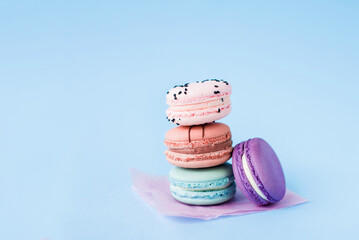 Close up view of stack of French macaroons on a blue background. Sweet and colorful French macaroons. Dessert. Homemade sweets. Café dessert. Selective focus